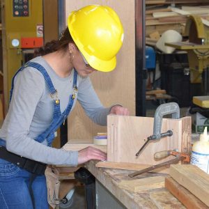 A Magnet high school student works on wood