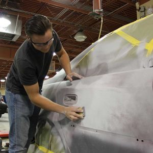 A Magnet high school student works on a car