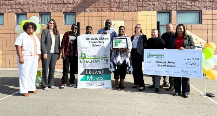 Ekuwah Moses smiles with her family and colleagues as she receives the 'LifeChanger of the Year' award.