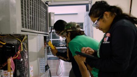 Students working on an air conditioning unit