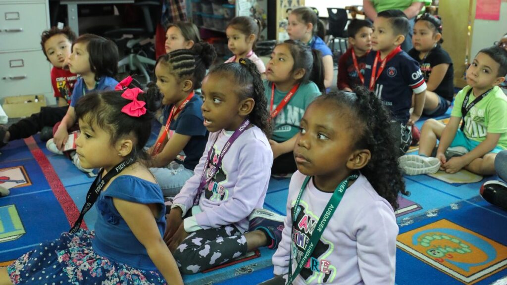 Elementary school students sitting in a classroom.