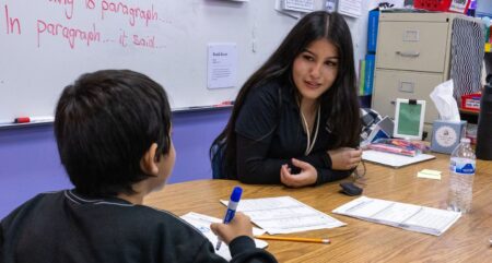 Arlene Ramirez, a student in the Teacher Academy College Pathway Program at Rancho High School works with an elementary student.