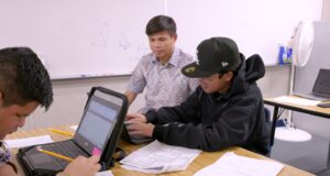 A teacher tutors students in the Academic Support and Community Service Center.